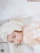 A woman with a towel wrapped around her head in a bathtub.