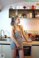 A woman standing in a kitchen next to a counter.