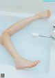 A woman's legs in a bathtub with water on them.