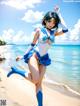 A woman in a blue and white outfit on a beach.