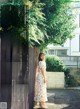 A woman standing in front of a wooden fence.