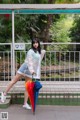 A woman standing on a train platform holding an umbrella.